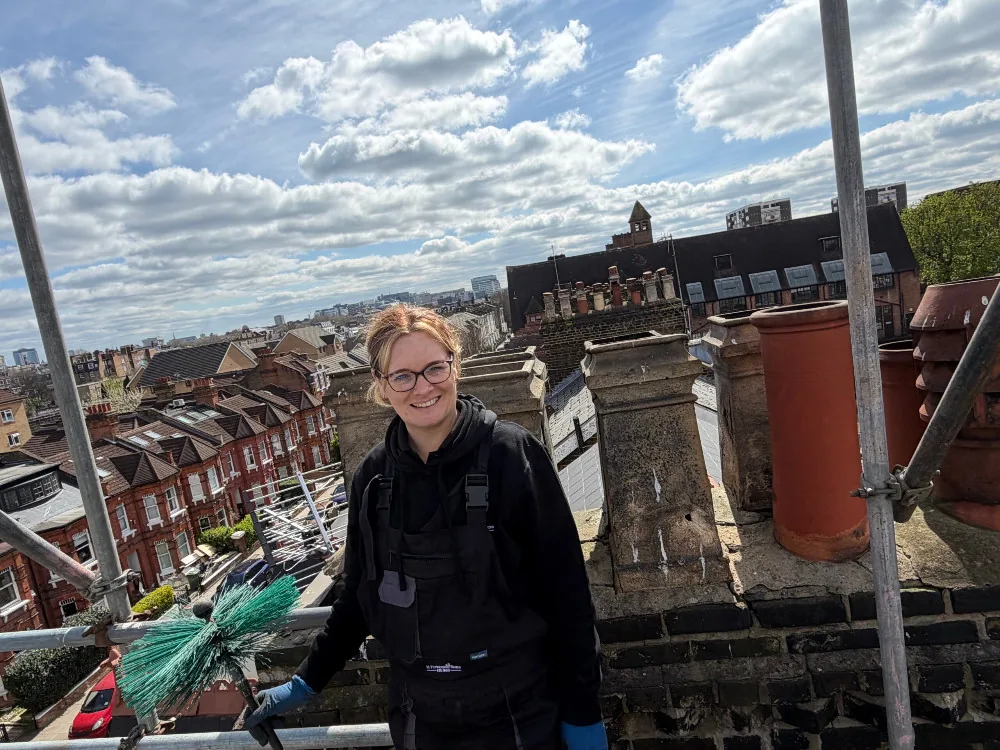 Lucie Chamberlain, female chimney sweep, working on a London rooftop
